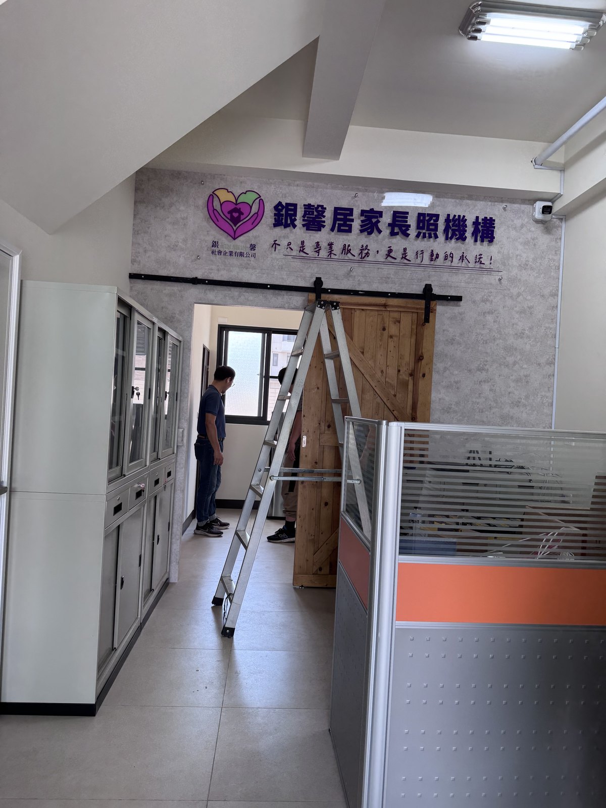 銀馨居家長照機構室內全景,形象牆位在櫃檯後方的主要視覺牆面