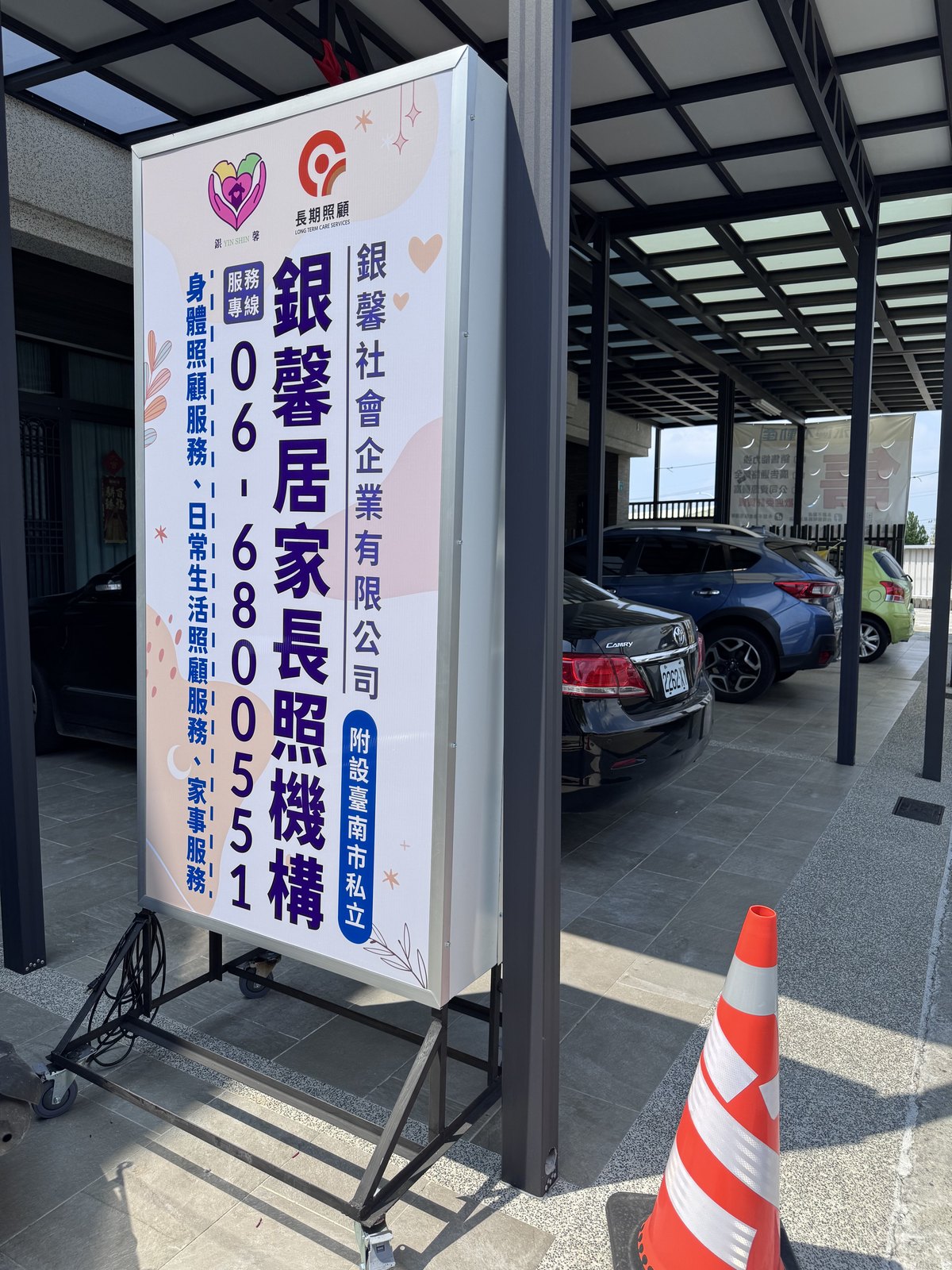 銀馨居家長照機構的直式推車招牌,附輪子與 L 型腳架可推到戶外
