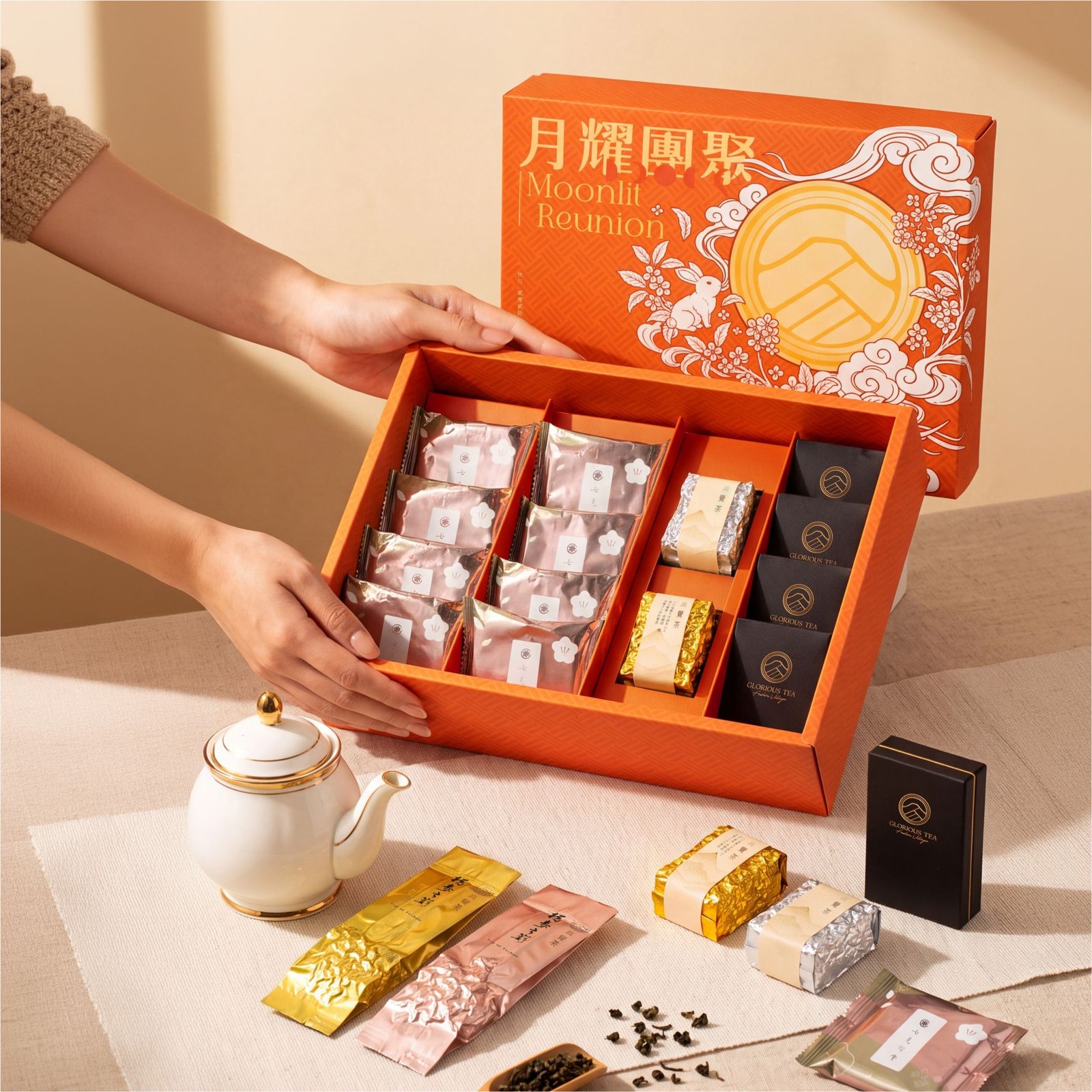 中秋禮盒開盒 分格內襯配置 雙手打開月耀團聚中秋禮盒,可看見分格內襯中的點心、茶包與茶磚