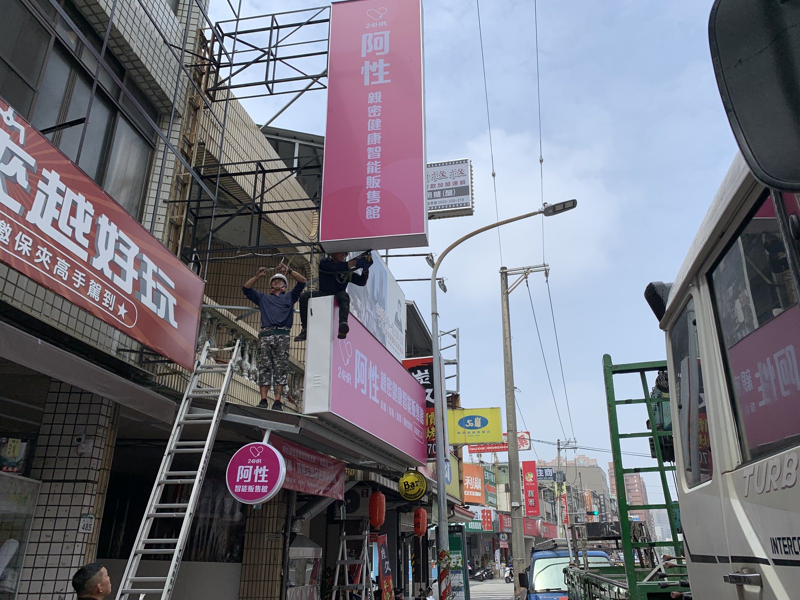 招牌高處安裝作業,人員在屋頂固定不鏽鋼支撐