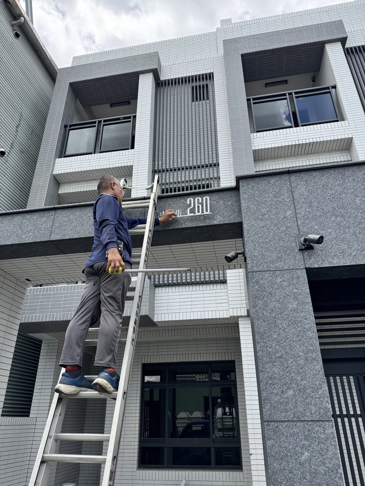 招牌安裝施工:師傅登梯進行建案門牌安裝,高雄仁武招牌施工 招牌安裝施工:師傅登梯進行建案門牌安裝,高雄仁武招牌施工