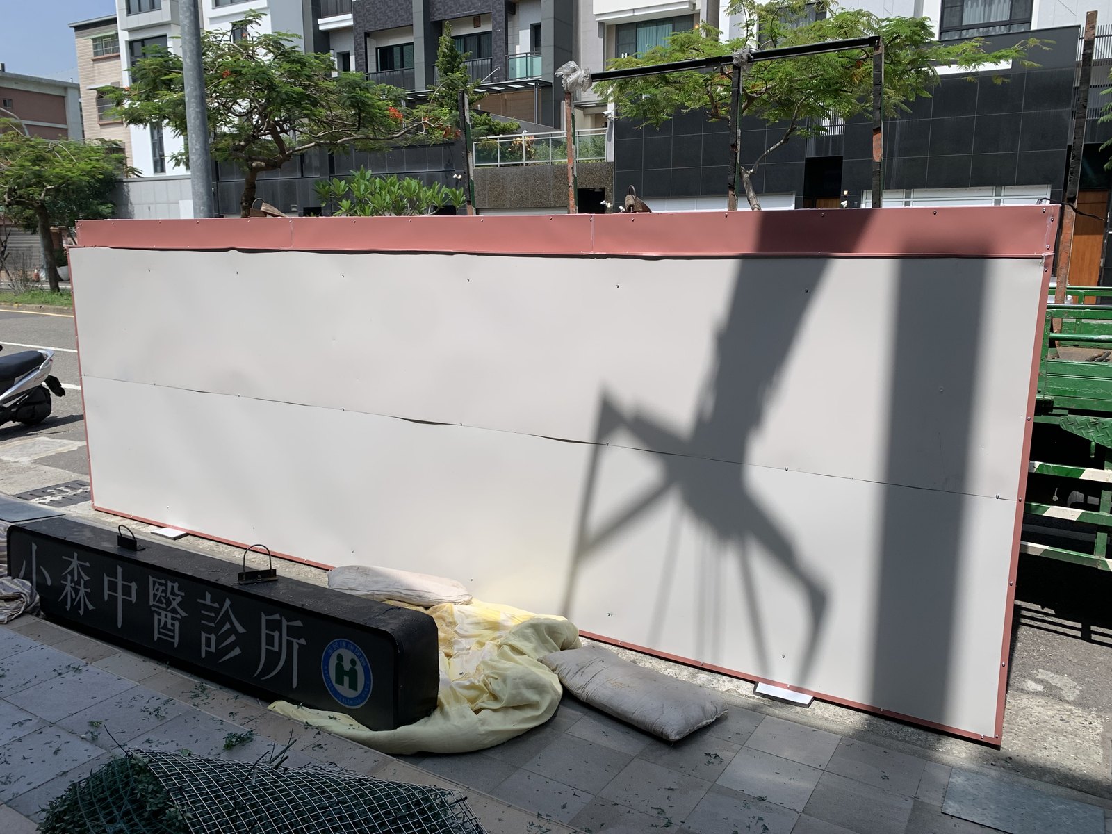 無接縫招牌板面在地面組裝,旁邊為拆下的舊招牌