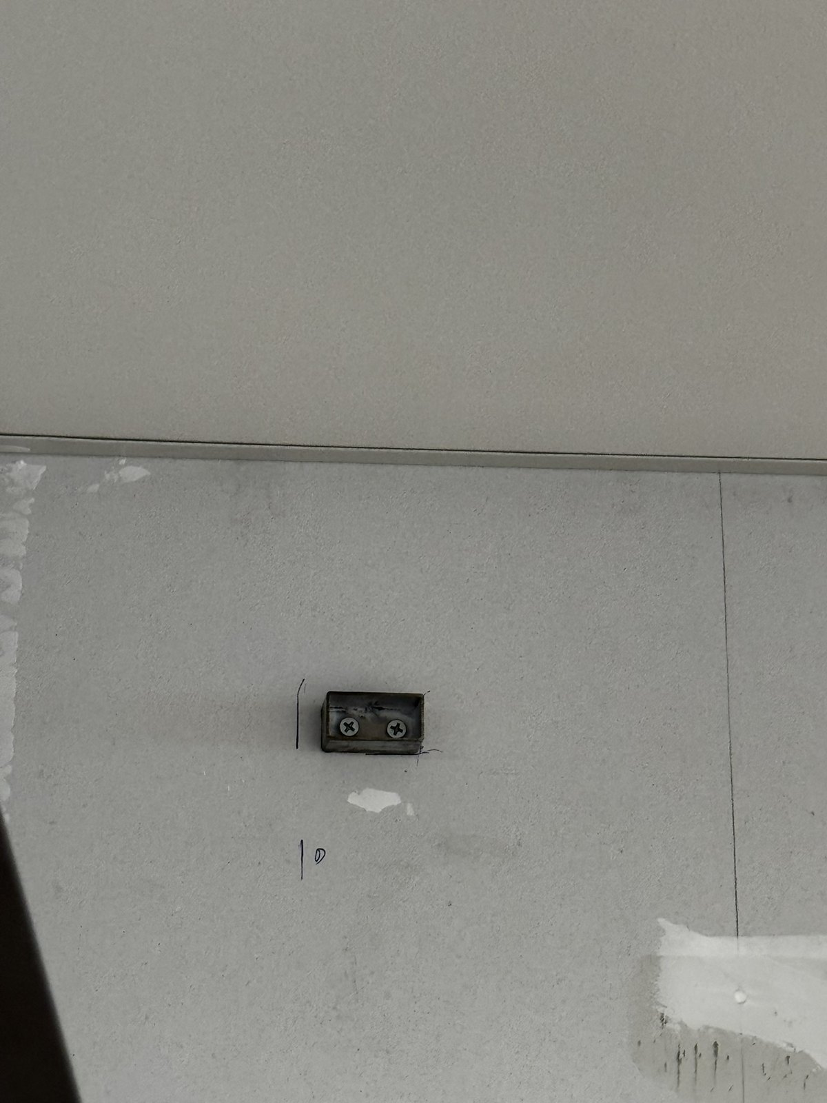 形象牆施工前的白色牆面,批土補平後等待金屬方管定位