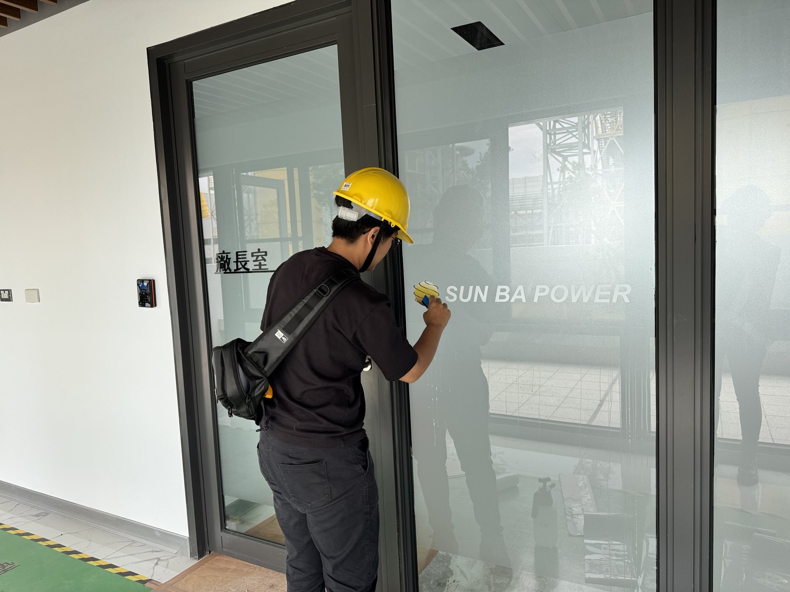 玻璃腰帶施工中,工班於玻璃隔間逐片貼附